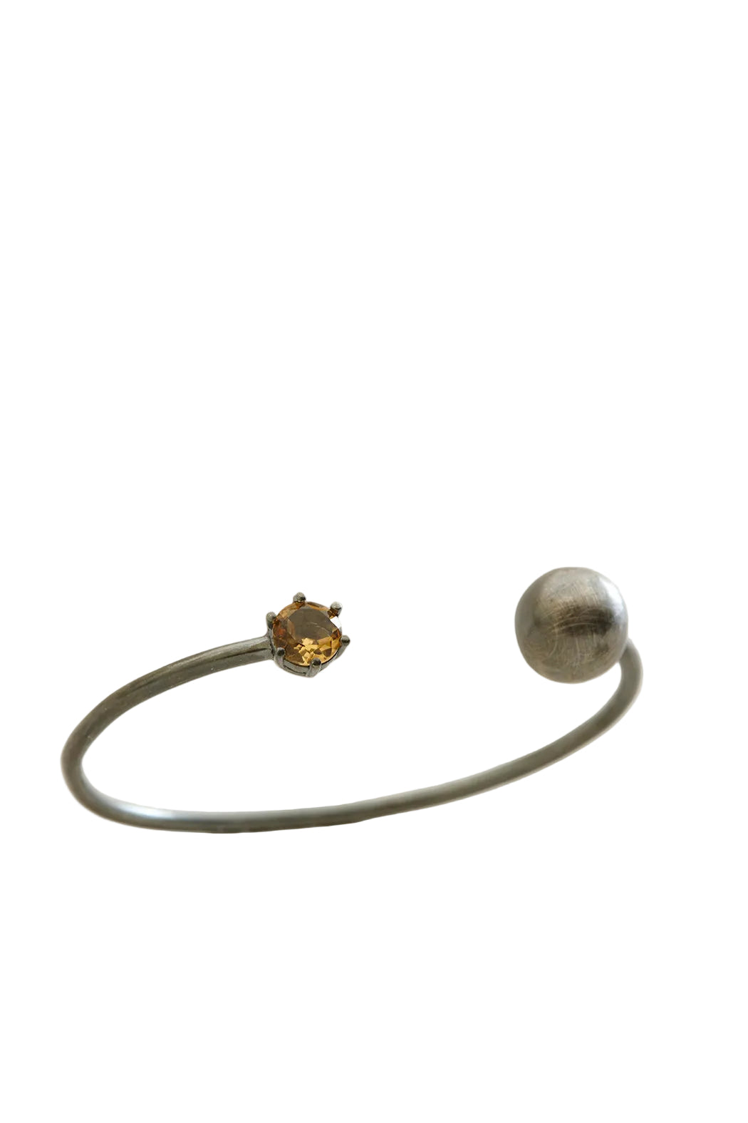 Silver ring with a small gemstone on a light beige background