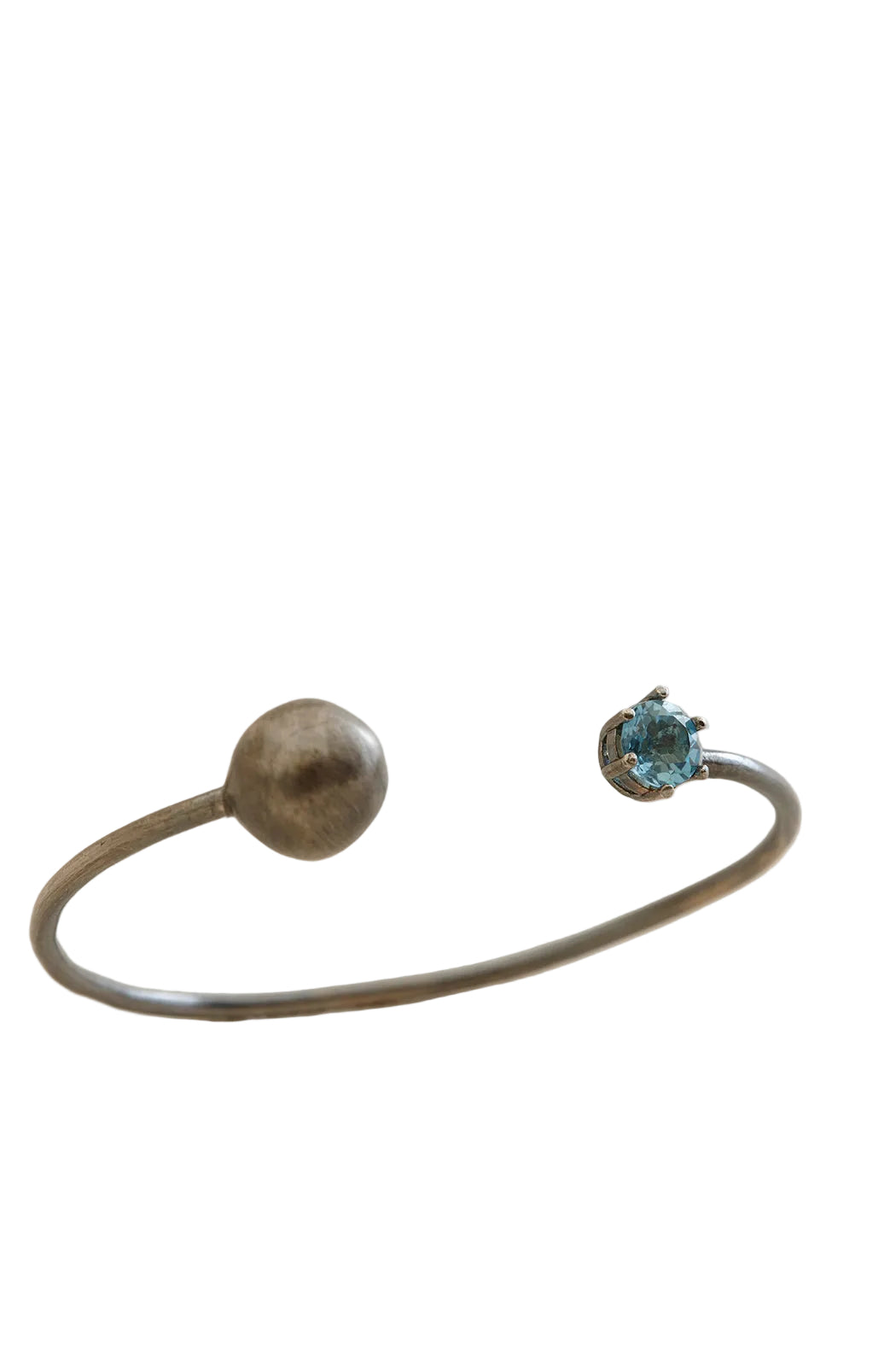 Silver bracelet with a round and a smaller round gemstone on a beige background