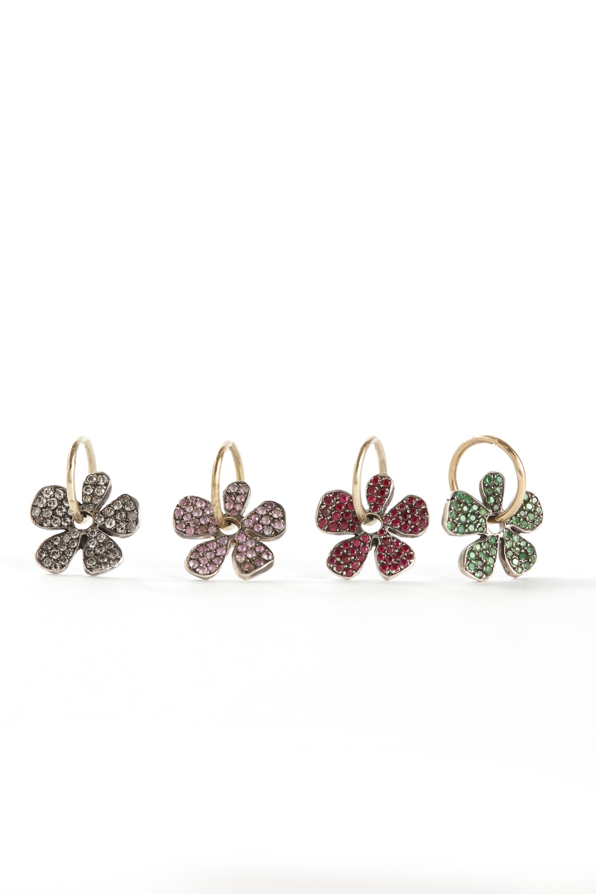 Four pairs of flower-shaped earrings with gemstones on a white background
