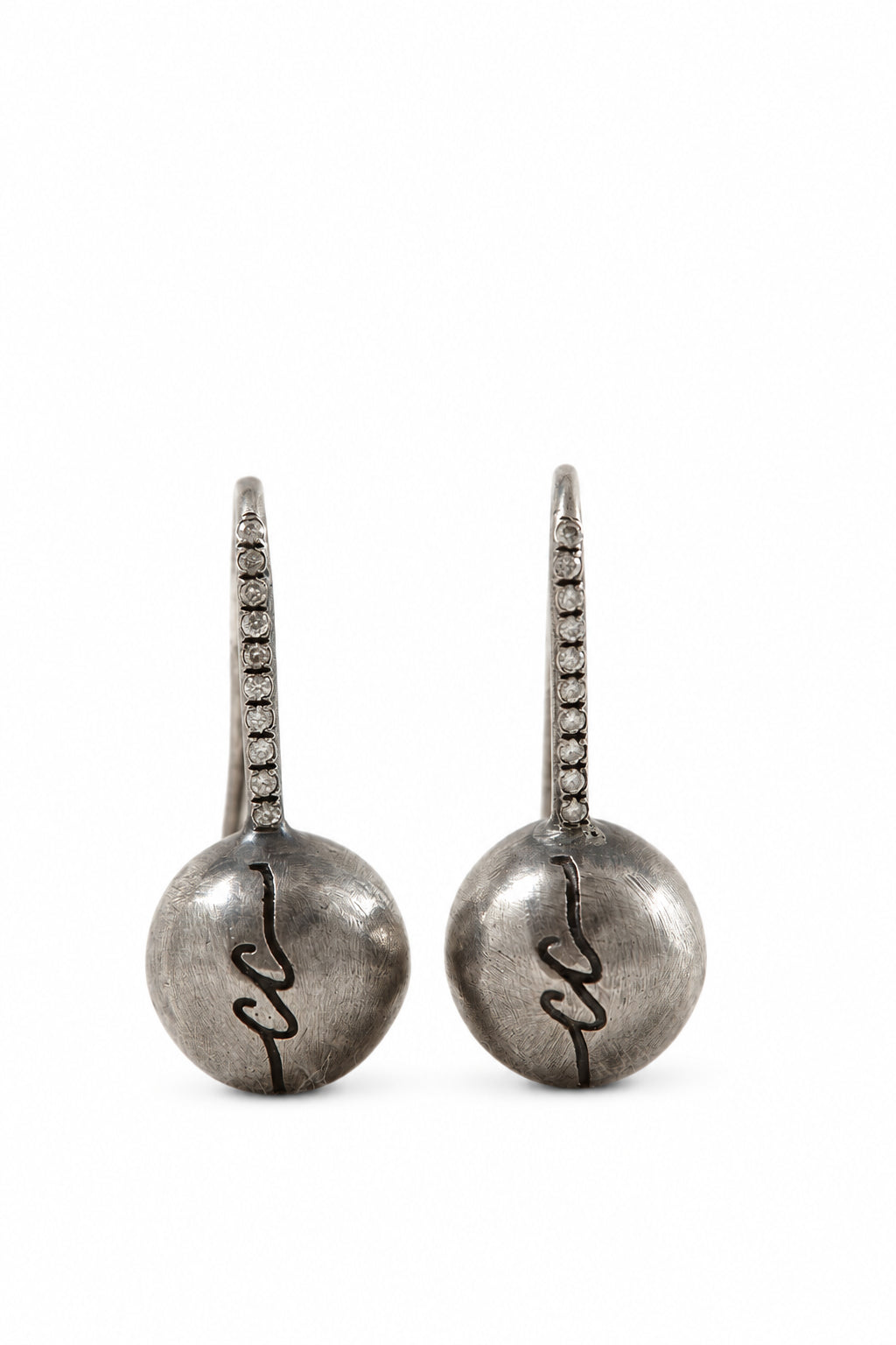 Pair of silver earrings with intricate designs on a light background