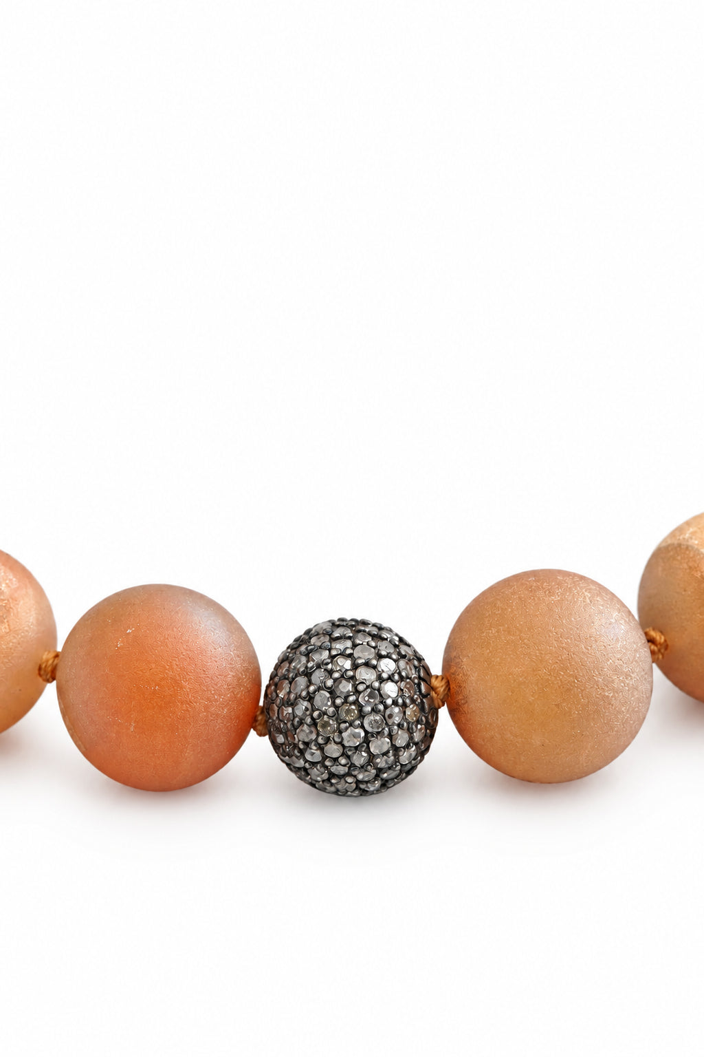 Necklace with brown beads and a silver beaded clasp on a light fabric background