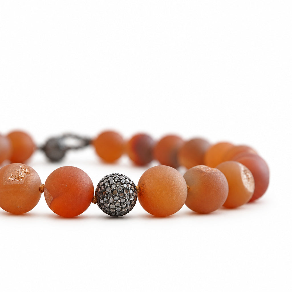 Necklace with brown beads and a silver beaded accent on a light background