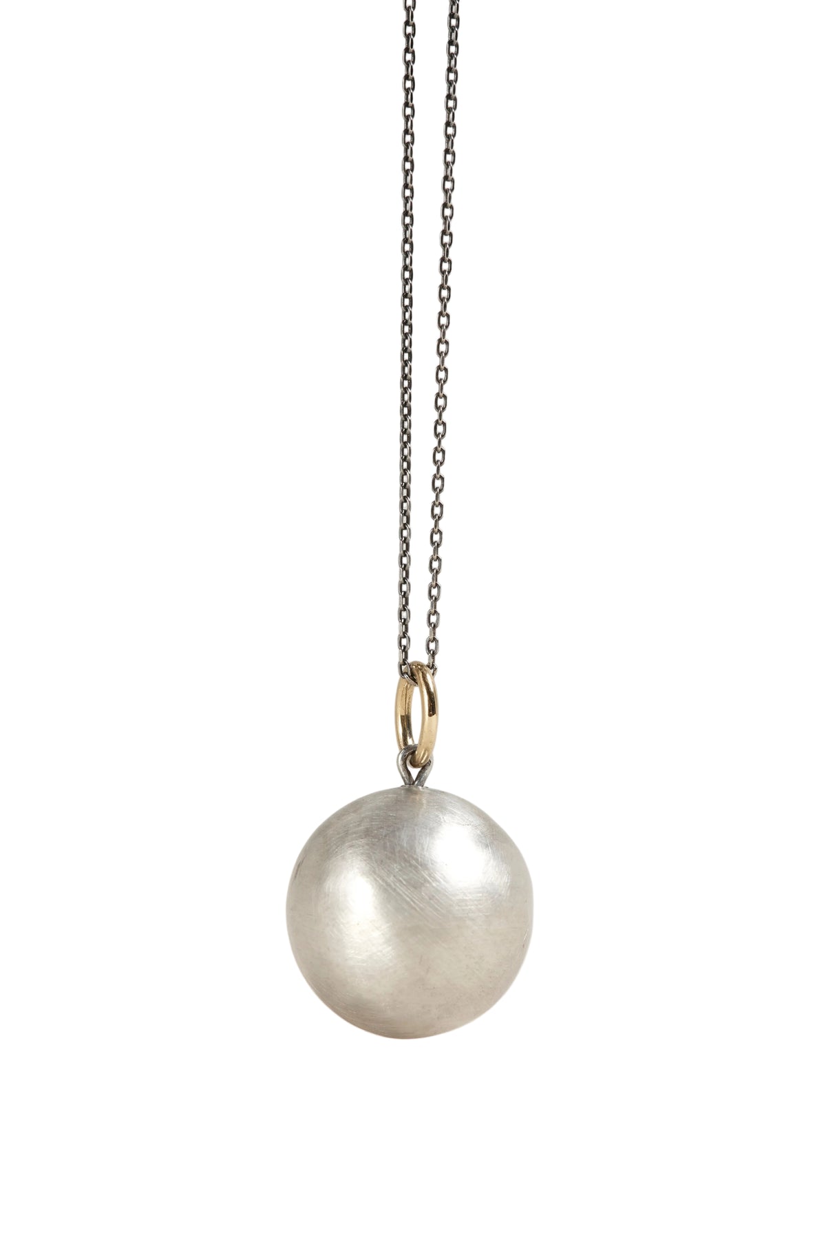 Silver necklace with a round pendant on a light gray background