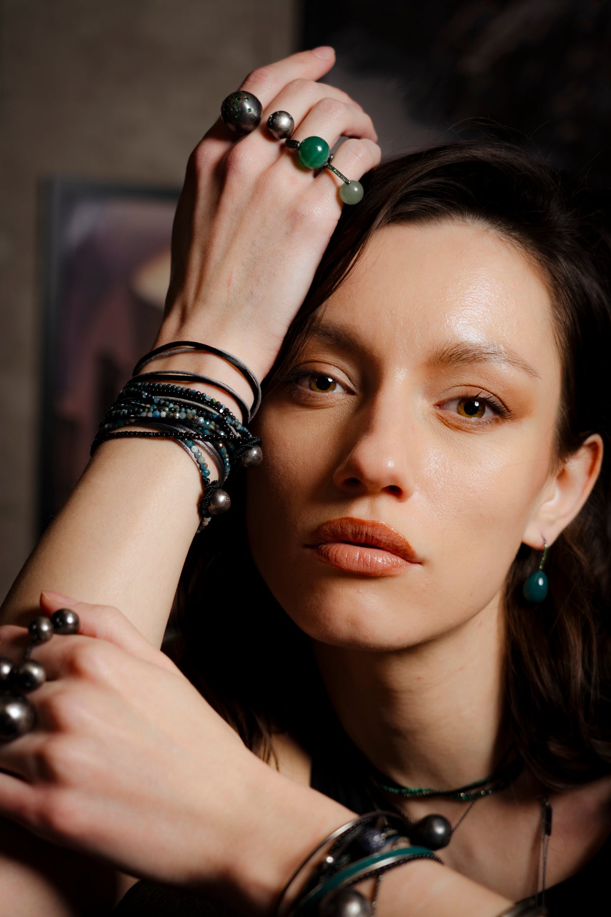 Woman with jewelry including rings and bracelets, with a blurred background