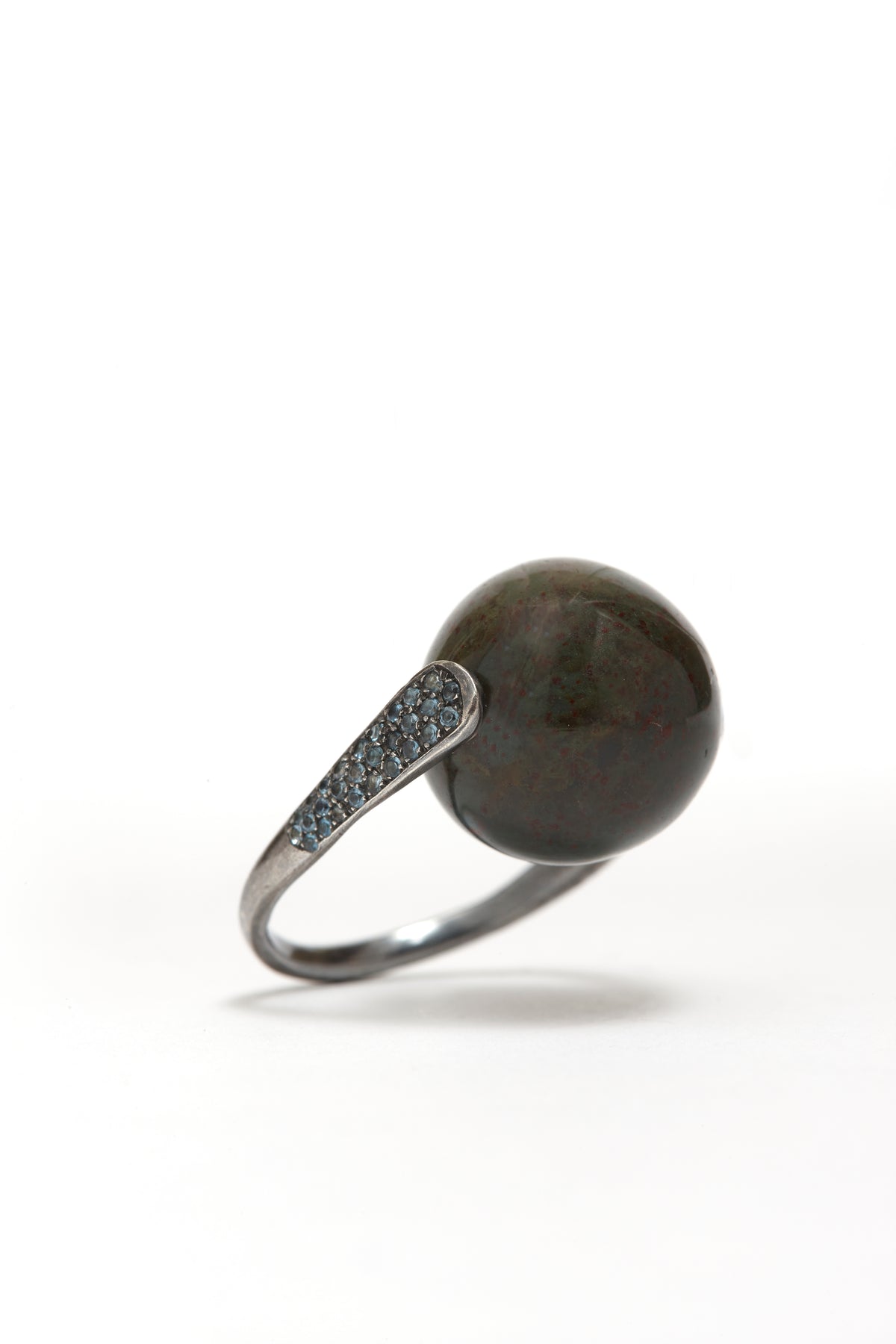 Ring with a dark stone and silver band on a white background