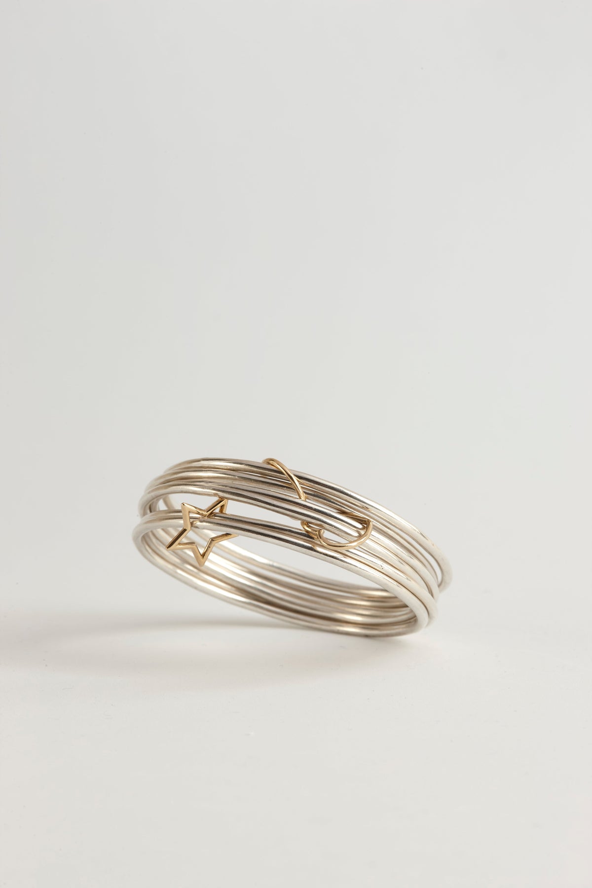 Cynthia Djurovic Together Bangles in sterling silver with 18k gold star and circle charms stacked on white background
