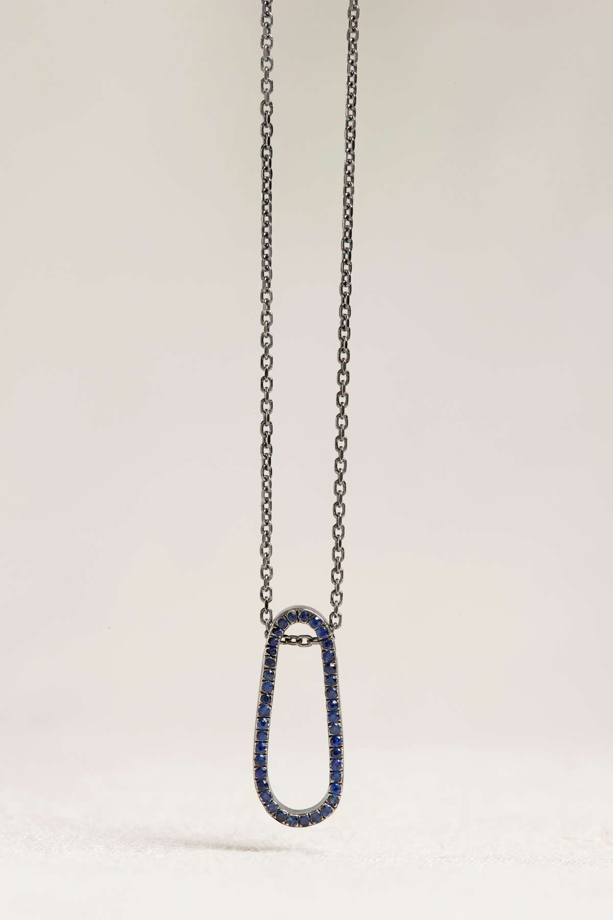 Cynthia Djurovic sterling silver necklace featuring a small water drop pendant set with royal blue sapphires.