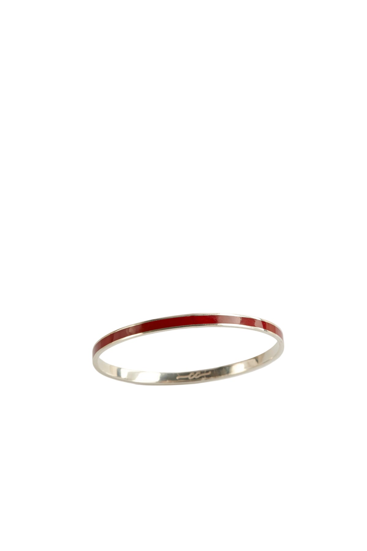 Thin silver ring with red interior on a light gray background