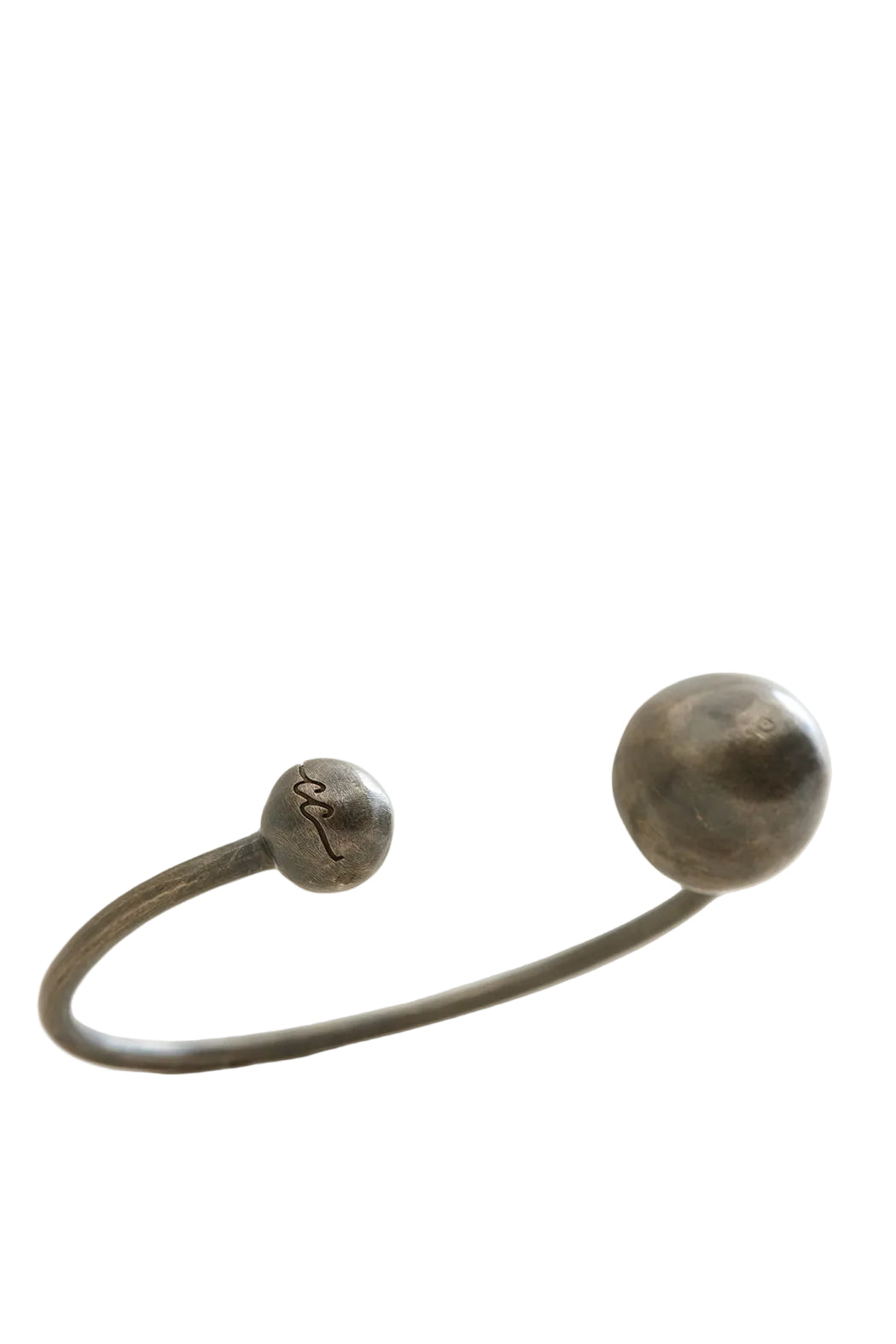 Bronze bracelet with spherical ends on a light gray background