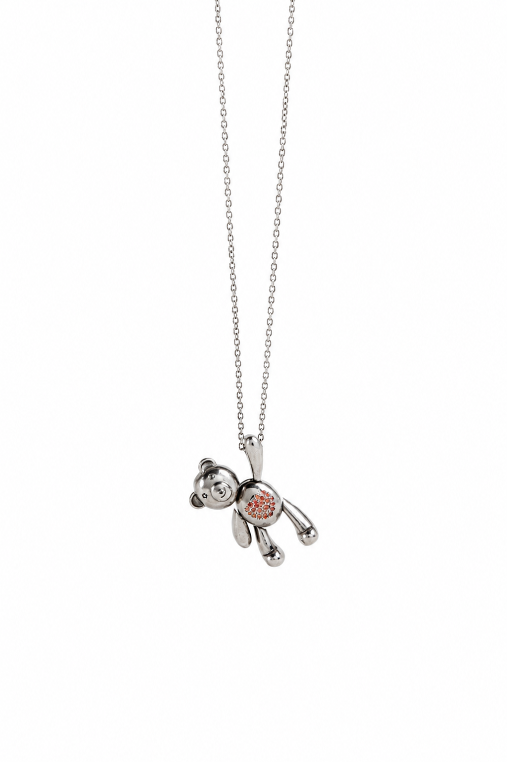 A silver teddy bear pendant necklace with a small orange and white patterned center detail, suspended on a delicate silver chain against a plain white background.