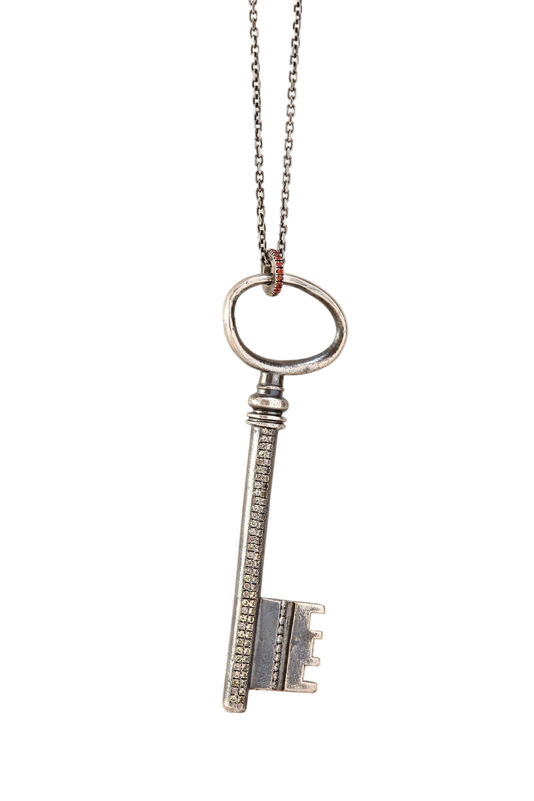 Silver key-shaped pendant on a chain against a light background