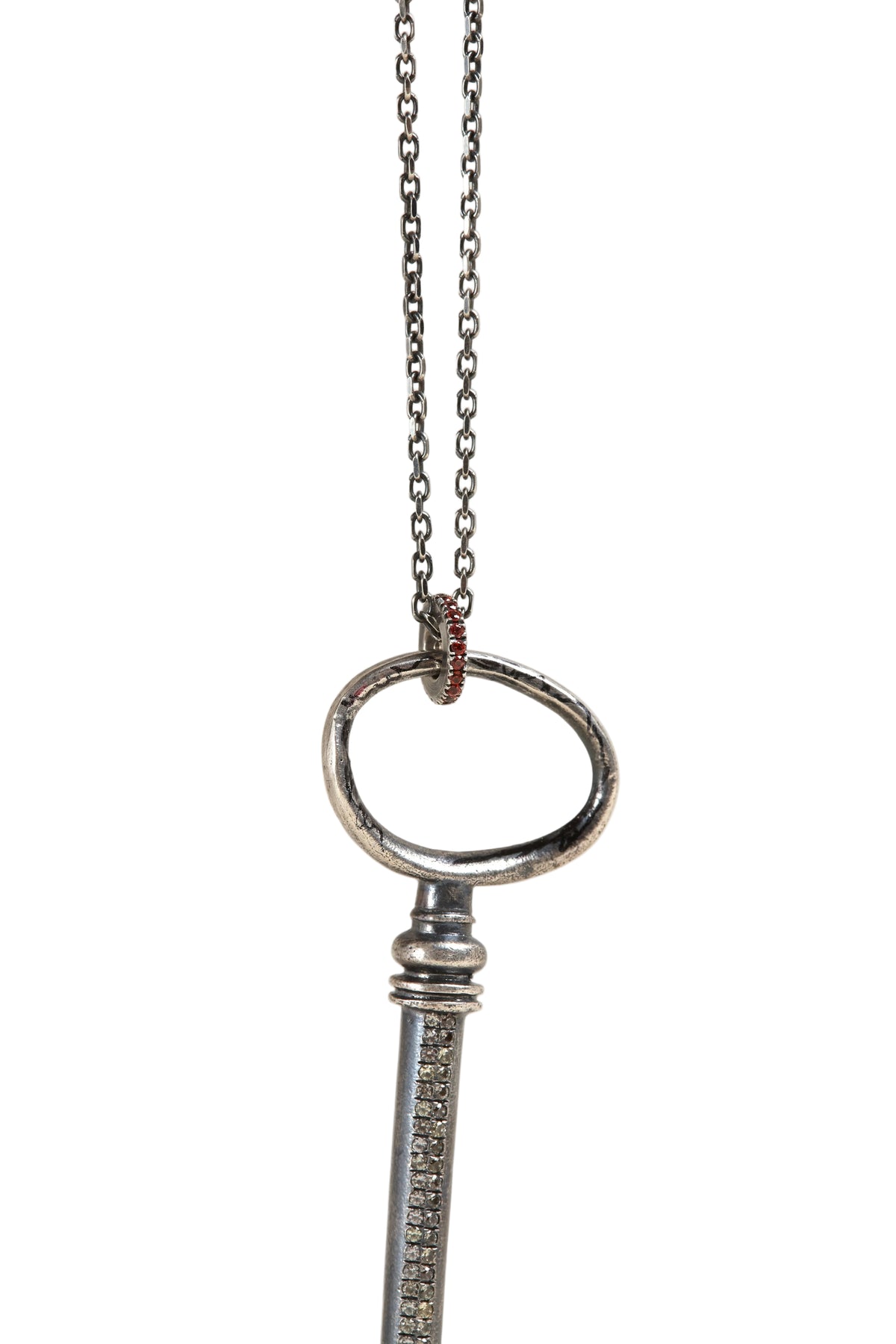 Silver key-shaped pendant on a chain against a light gray background