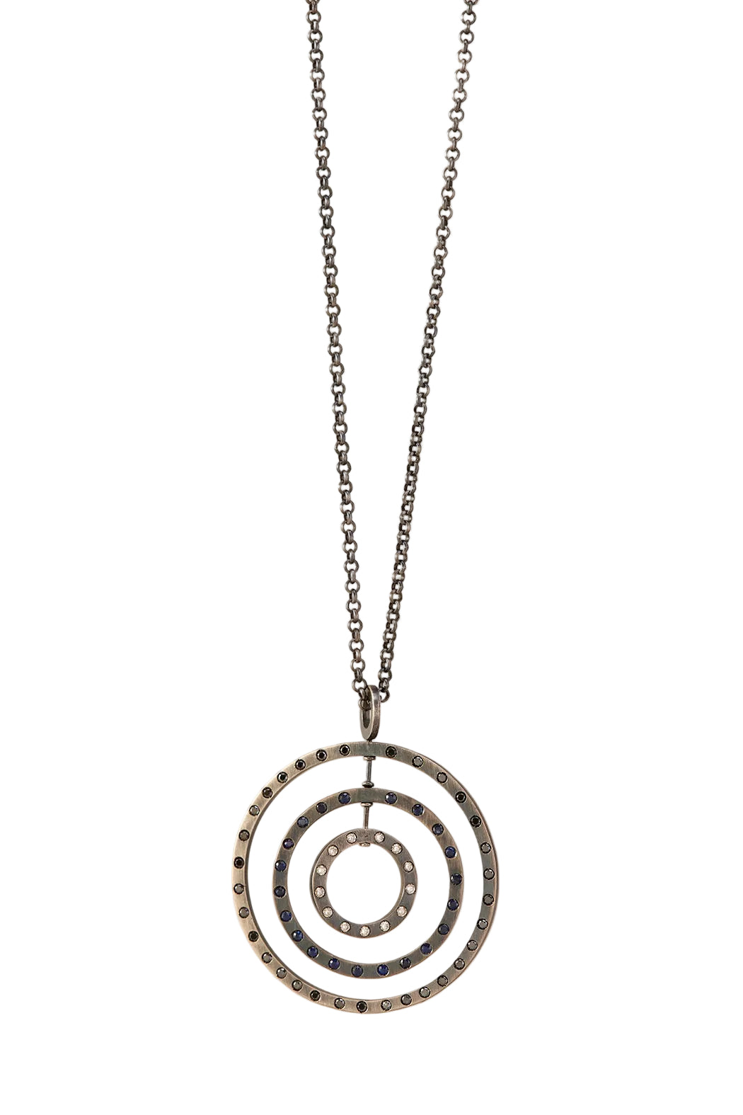 A silver-toned chain necklace with a triple concentric spiral pendant, embellished with small dark blue stones, shown against a plain white background.