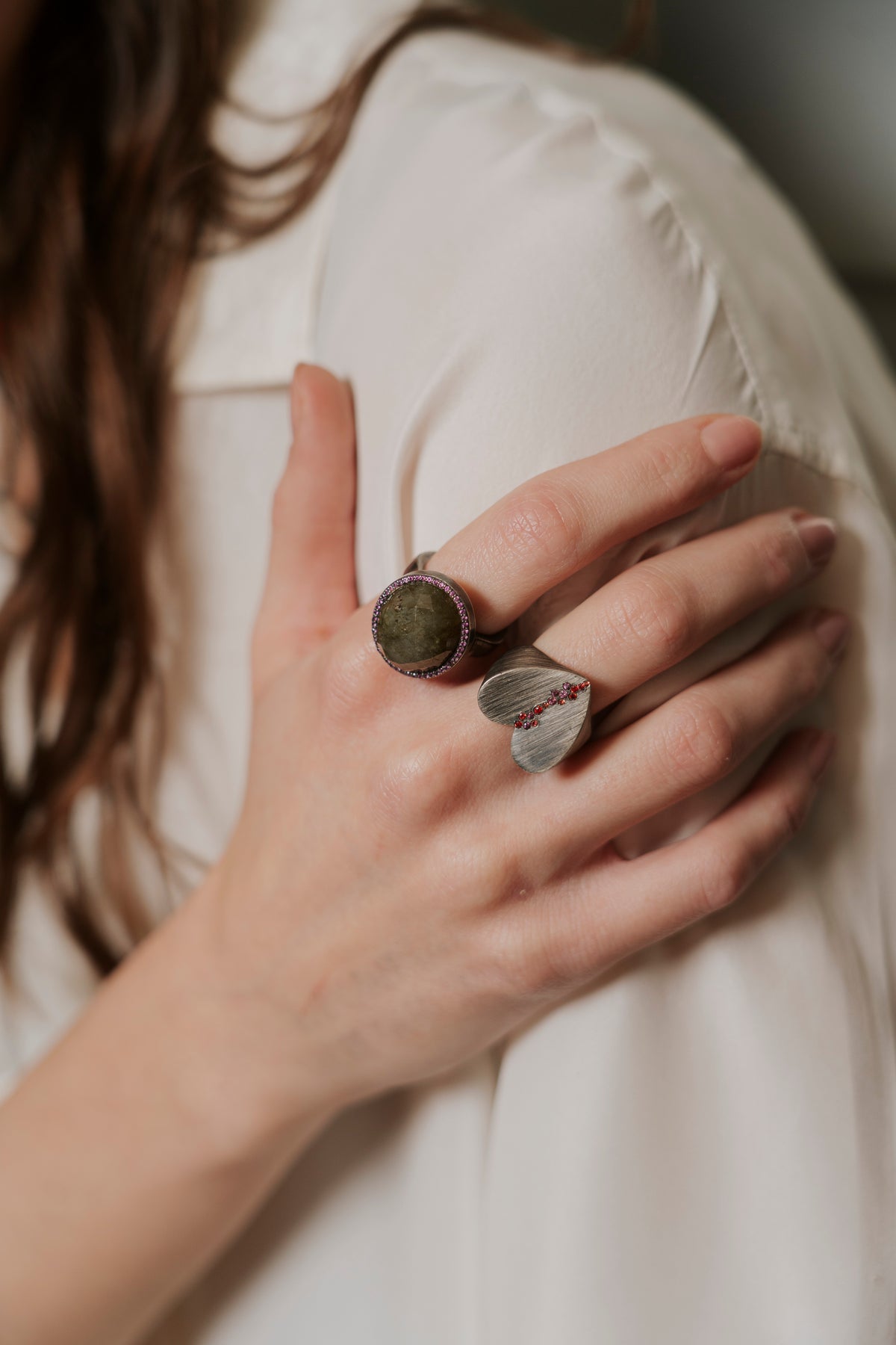 Close-up of a hand wearing two rings with a blurred background