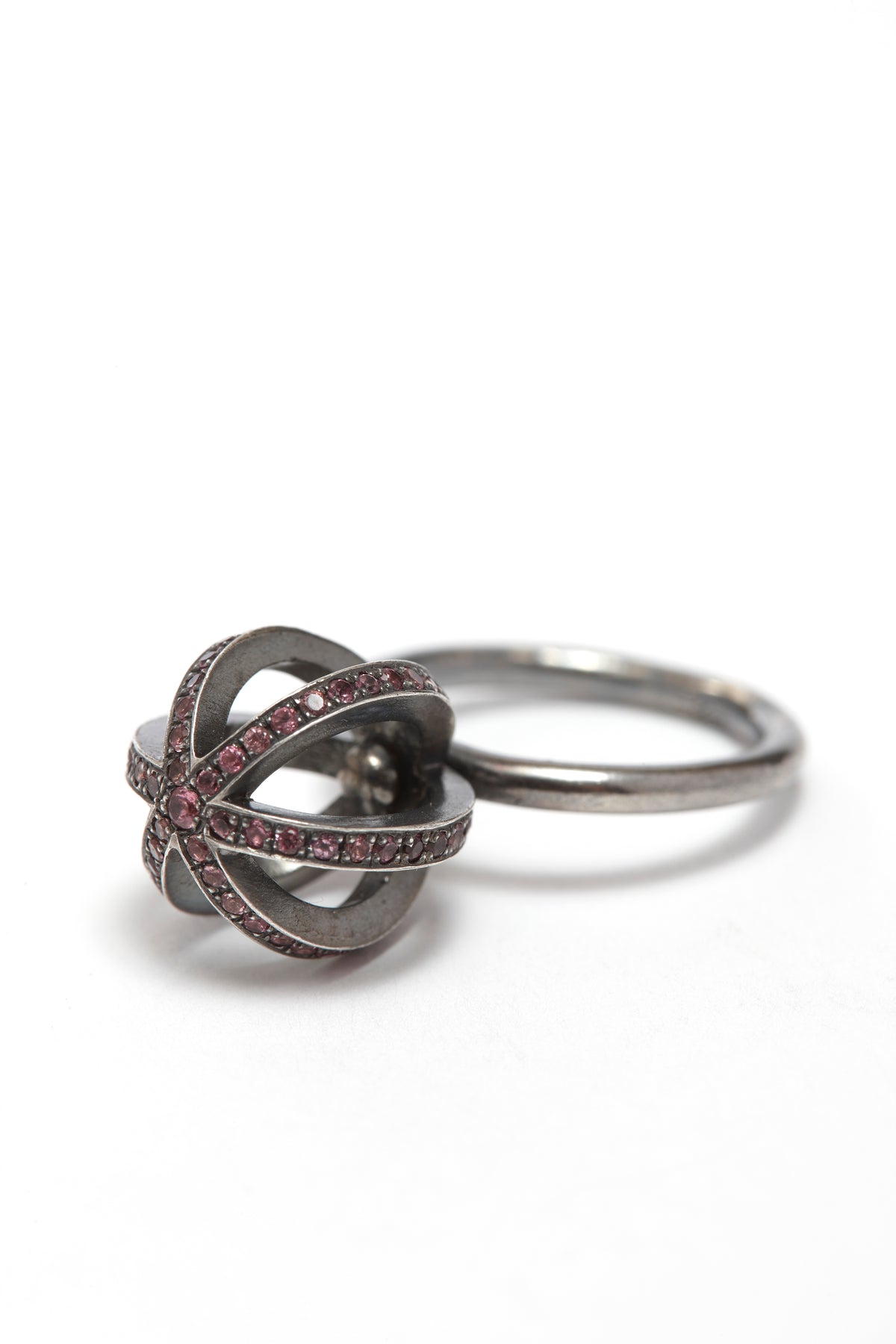 Silver ring with pink gemstones on a white background