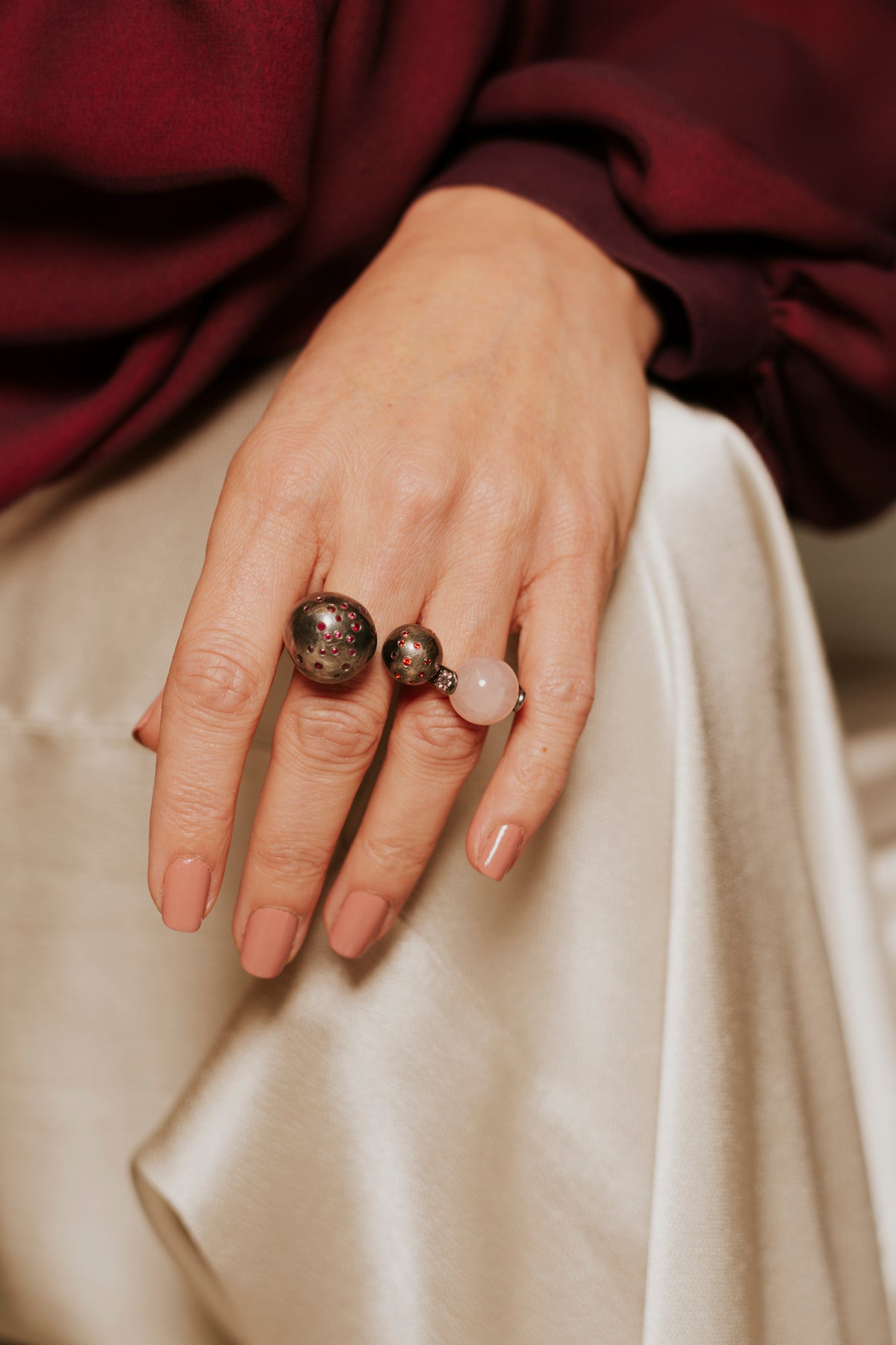 Close-up of a hand wearing two rings with a blurred background