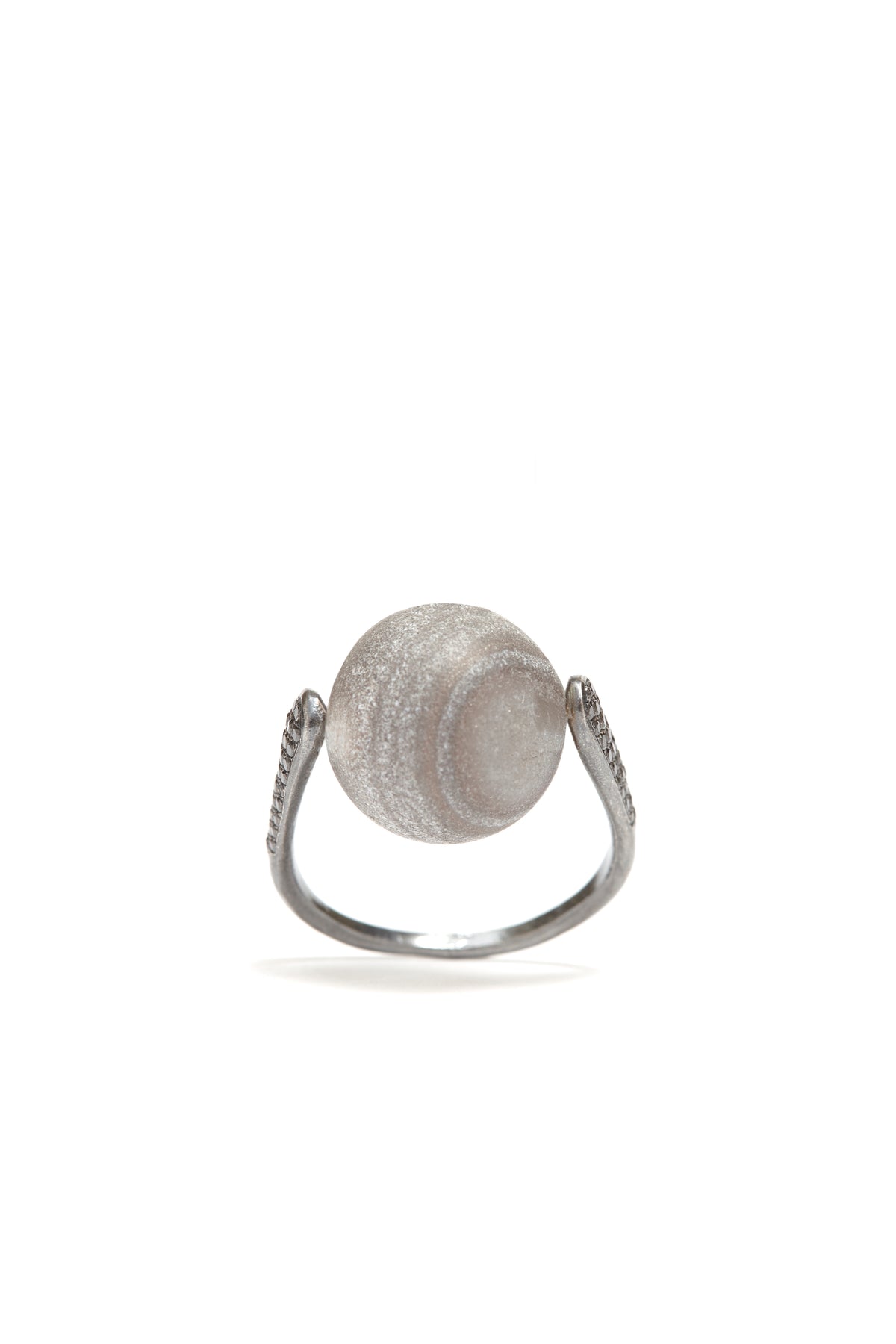 Silver ring with textured circular design on a white background