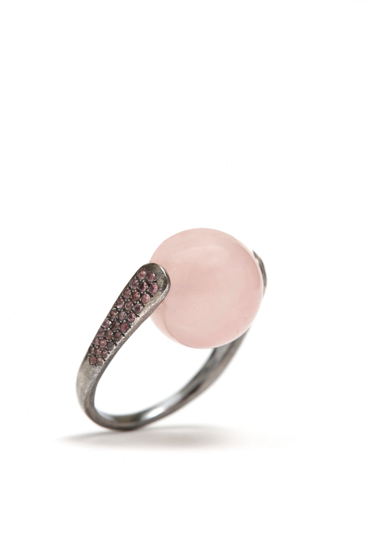 Ring with pink gemstone and silver band on a white background