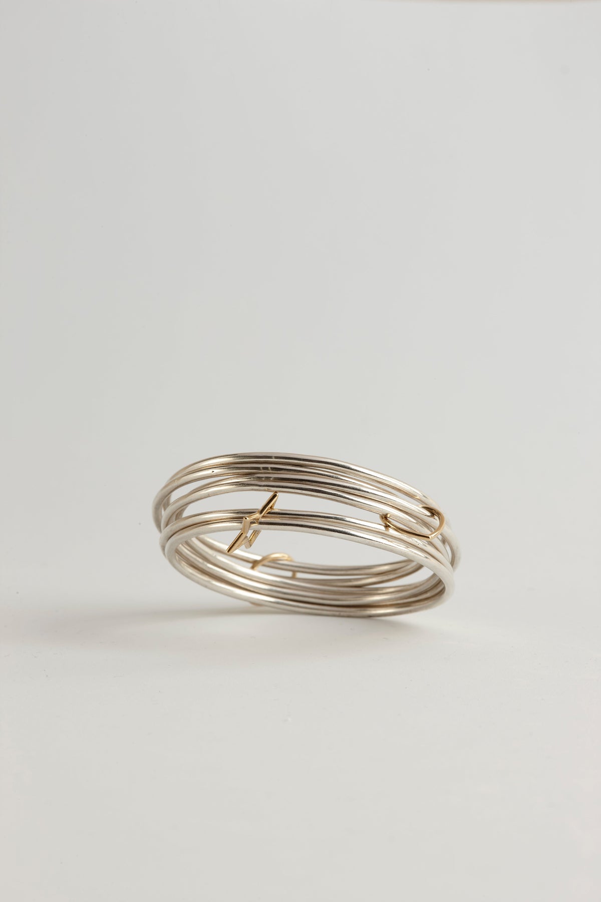 Cynthia Djurovic Together Bangles featuring sterling silver bands and an 18k gold circle of life charm stack.