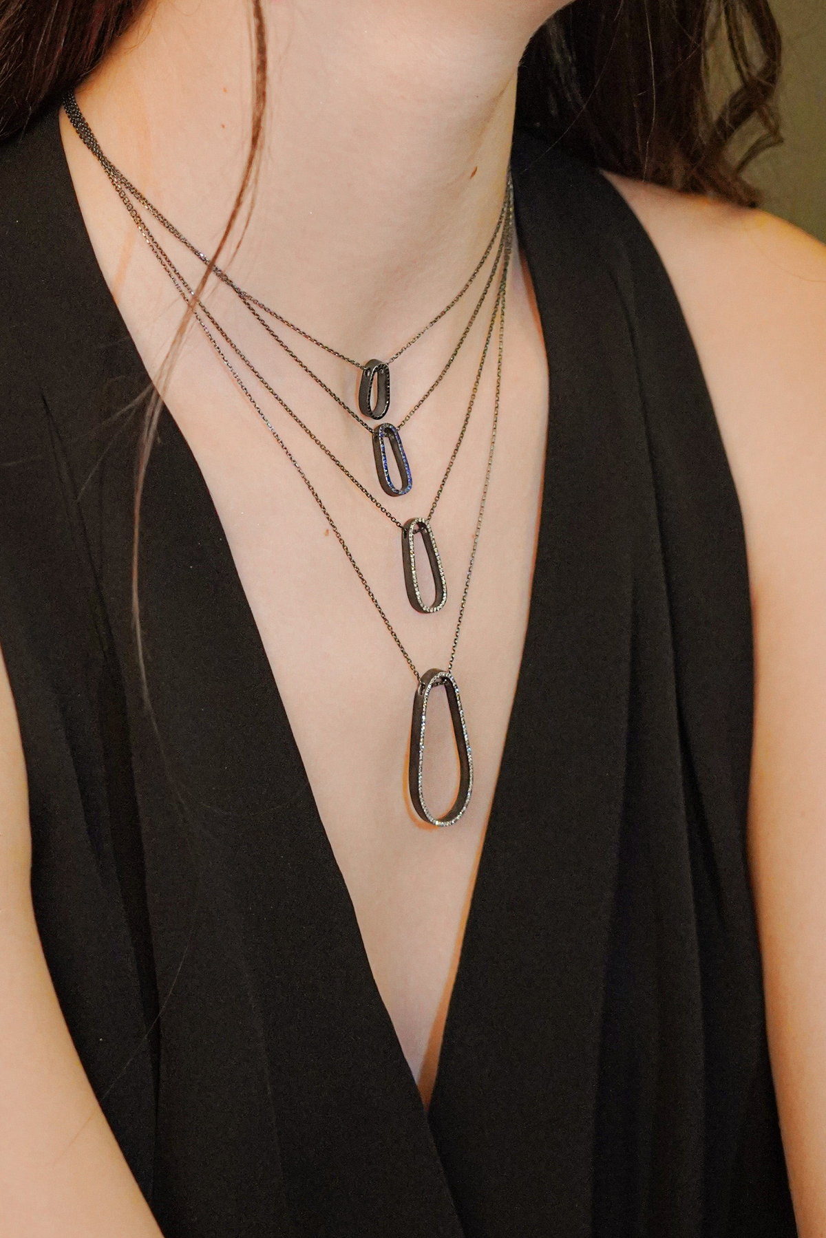 Cynthia Djurovic sterling silver water drop necklaces with royal blue sapphires worn layered on a model